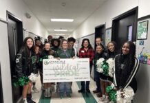 Cheerleaders and grant winner with a giant check